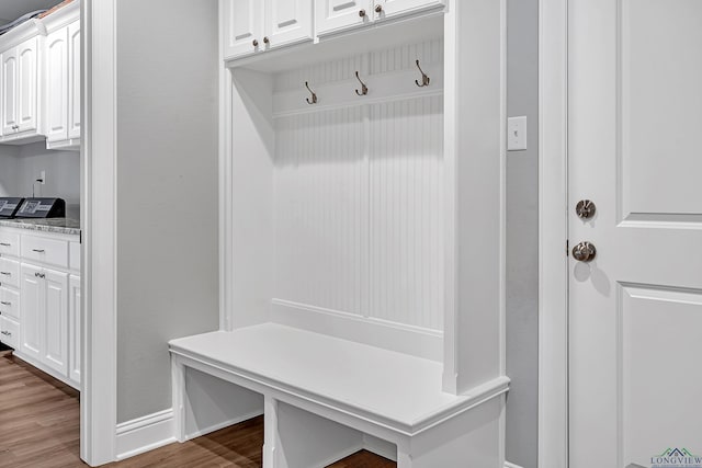 mudroom with wood finished floors and baseboards