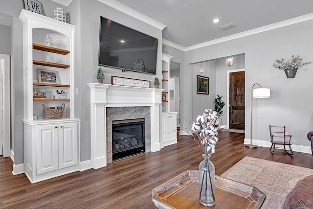 living room with baseboards, visible vents, built in features, dark wood-style floors, and a premium fireplace