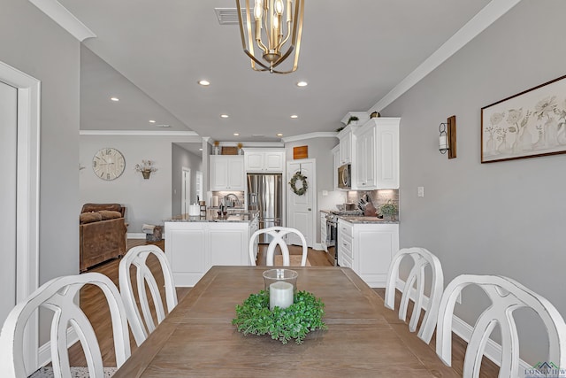 dining room featuring recessed lighting, visible vents, baseboards, light wood finished floors, and crown molding