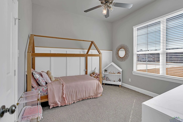 carpeted bedroom with ceiling fan and baseboards