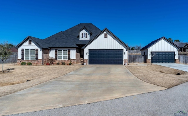 modern farmhouse with a garage, brick siding, and fence