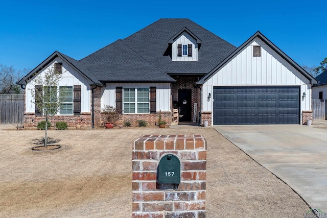 view of front of house with a garage, concrete driveway, brick siding, and fence