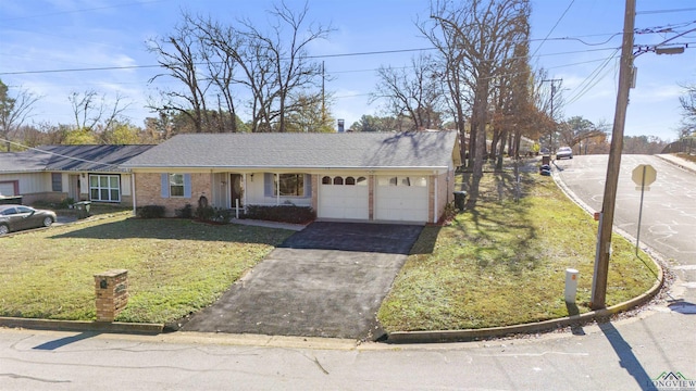 ranch-style home featuring a garage and a front lawn