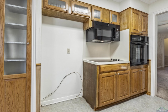 kitchen with black appliances and light colored carpet