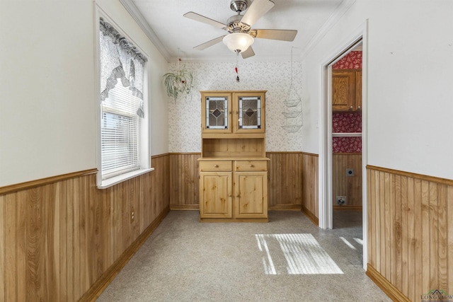 interior space with ceiling fan, crown molding, and light colored carpet