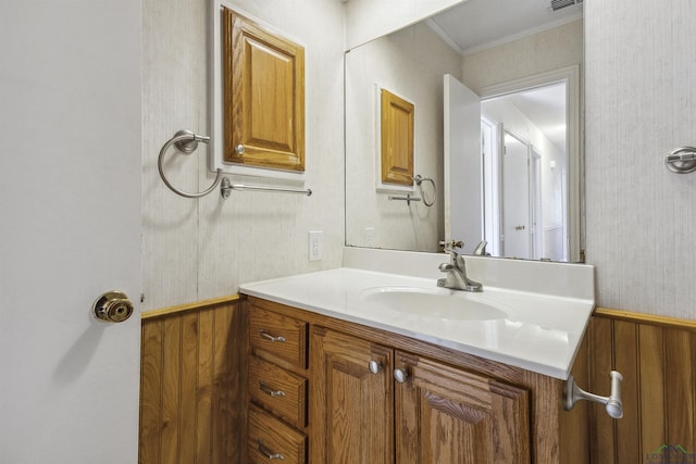 bathroom with vanity, crown molding, and wood walls