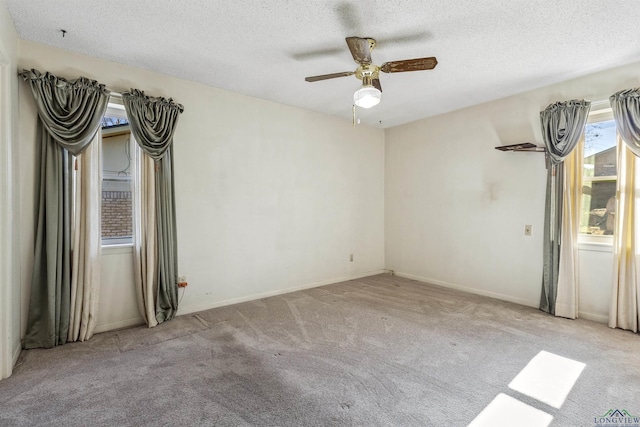 unfurnished room with a textured ceiling, ceiling fan, and light carpet