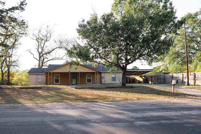 ranch-style house with covered porch and a carport