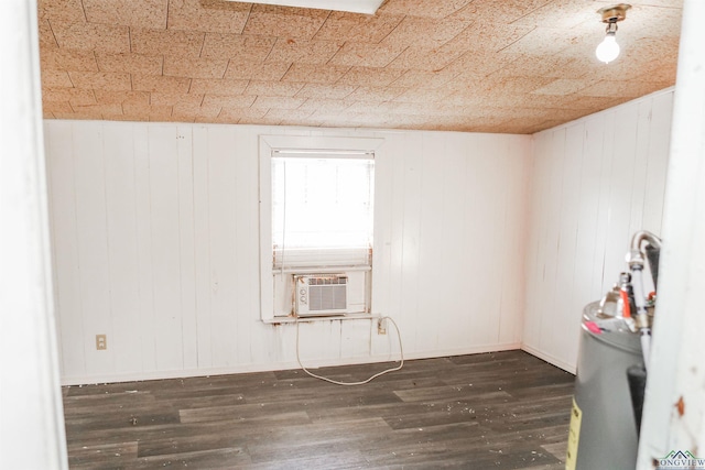 spare room featuring wood walls, dark hardwood / wood-style floors, and cooling unit