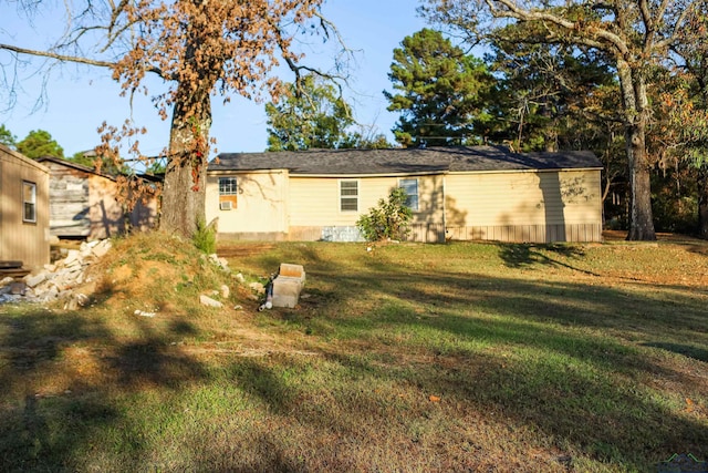 rear view of house featuring a lawn