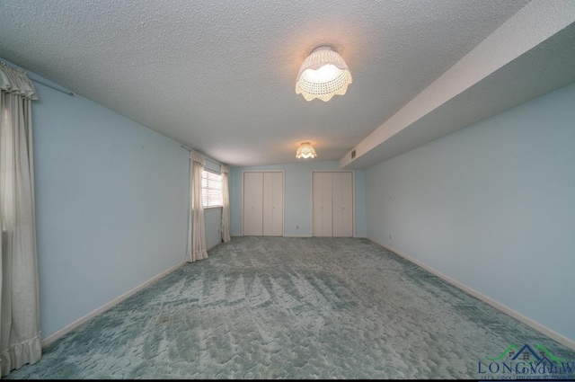 carpeted empty room featuring visible vents, baseboards, and a textured ceiling