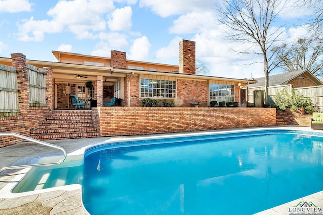 outdoor pool with a patio area, ceiling fan, and fence