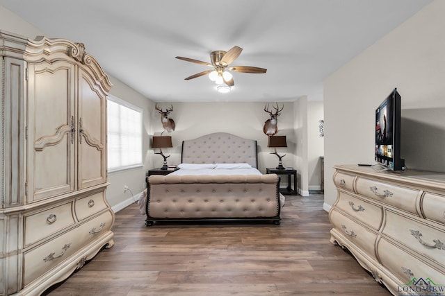 bedroom featuring ceiling fan, dark wood-type flooring, and baseboards