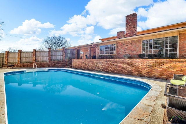 view of swimming pool with a fenced in pool and fence