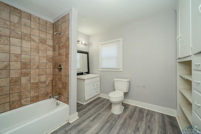 full bathroom with hardwood / wood-style flooring, tiled shower / bath combo, toilet, and vanity