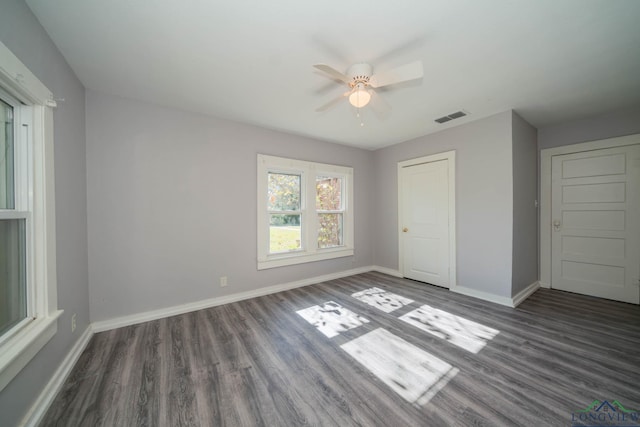 unfurnished bedroom featuring a closet, ceiling fan, and dark hardwood / wood-style flooring