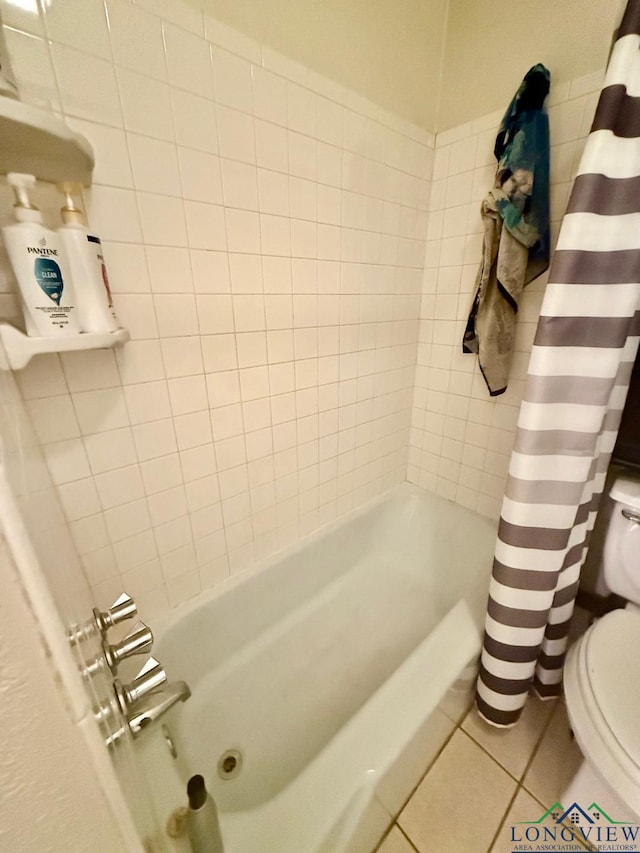 bathroom featuring tile patterned floors, toilet, and shower / bath combo with shower curtain