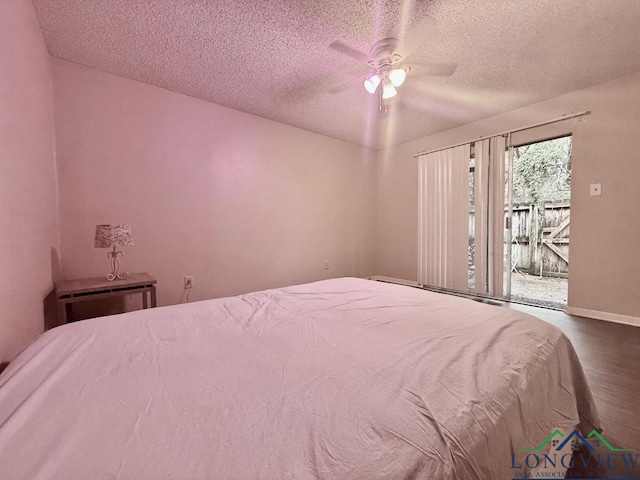 bedroom with ceiling fan, wood-type flooring, access to exterior, and a textured ceiling