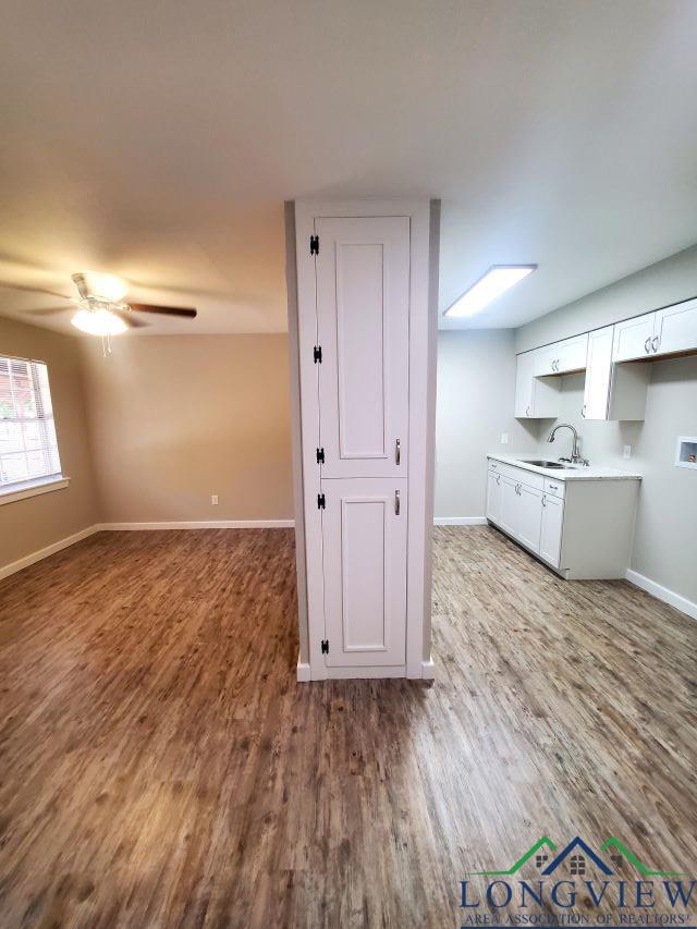 interior space featuring ceiling fan, sink, and light wood-type flooring