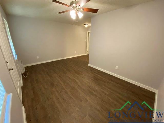 empty room with a textured ceiling, dark hardwood / wood-style floors, and ceiling fan