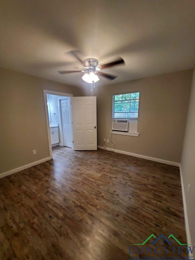 empty room with ceiling fan and dark wood-type flooring