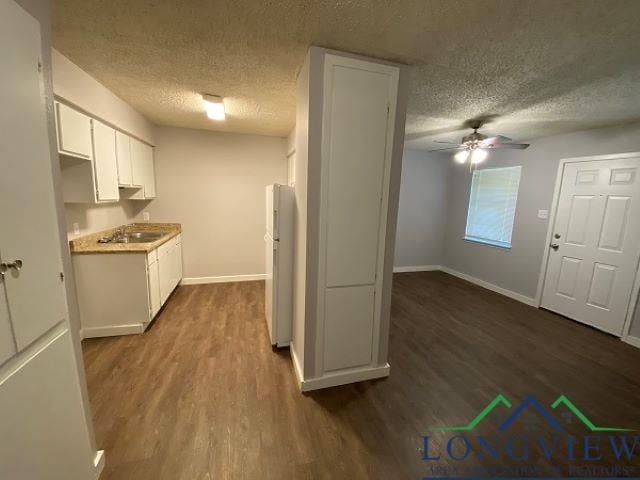 kitchen with white cabinets, white refrigerator, dark hardwood / wood-style floors, and sink