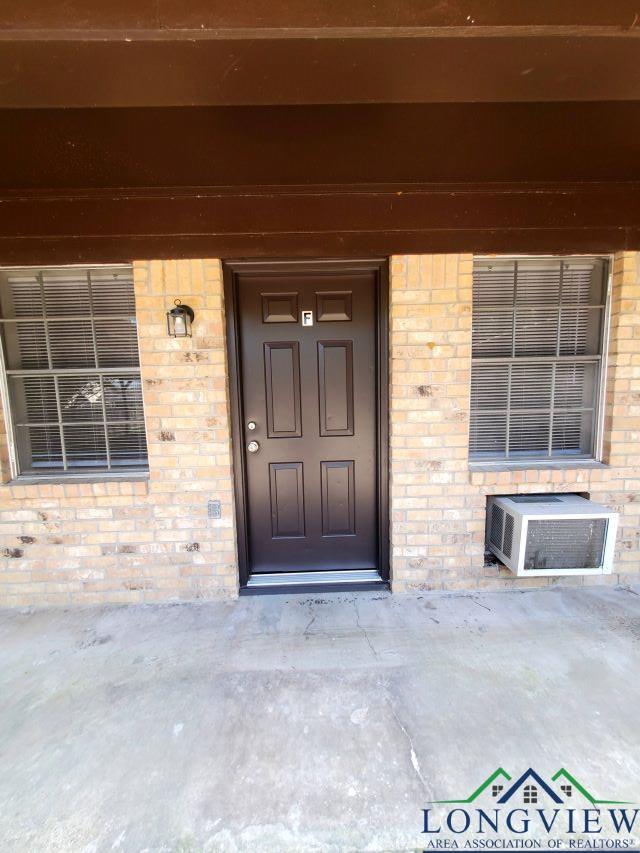 doorway to property featuring an AC wall unit