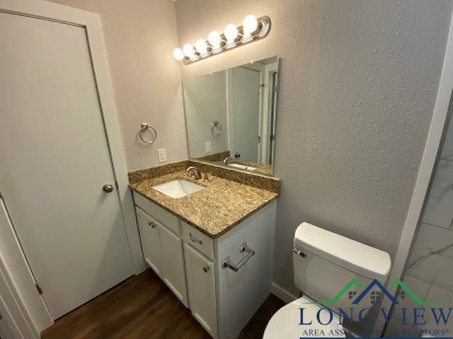 bathroom with vanity, hardwood / wood-style flooring, and toilet