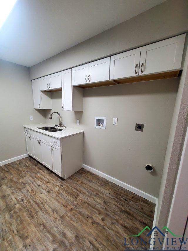 clothes washing area with washer hookup, electric dryer hookup, dark hardwood / wood-style floors, and sink