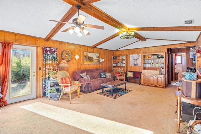 living room featuring light carpet, a textured ceiling, lofted ceiling with beams, and ceiling fan