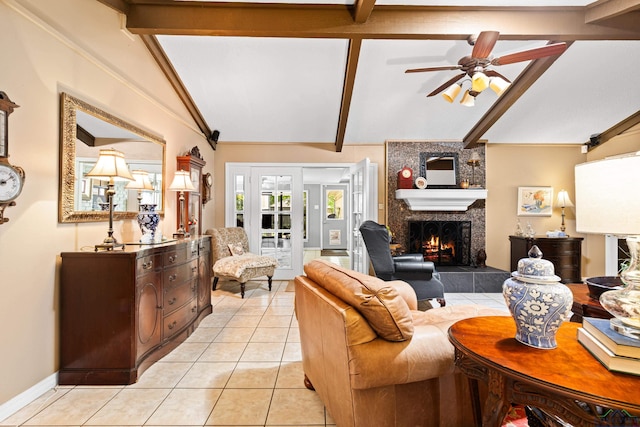 living area with a tile fireplace, a ceiling fan, lofted ceiling with beams, baseboards, and light tile patterned flooring
