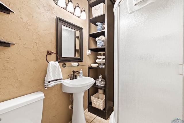 bathroom with toilet and tile patterned floors