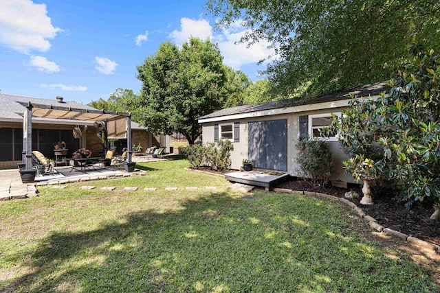 view of yard featuring a patio area, a pergola, and an outbuilding