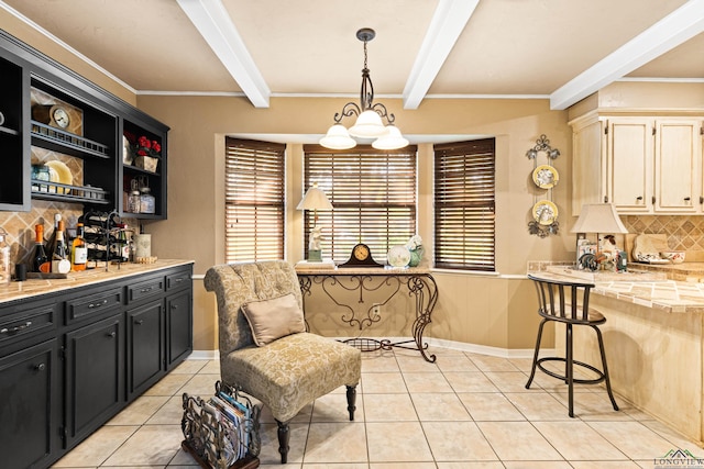 dining area with light tile patterned floors, beam ceiling, and a dry bar