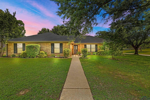 single story home with brick siding and a front lawn
