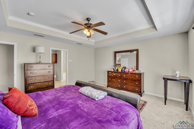 bedroom with baseboards, a tray ceiling, visible vents, and light colored carpet