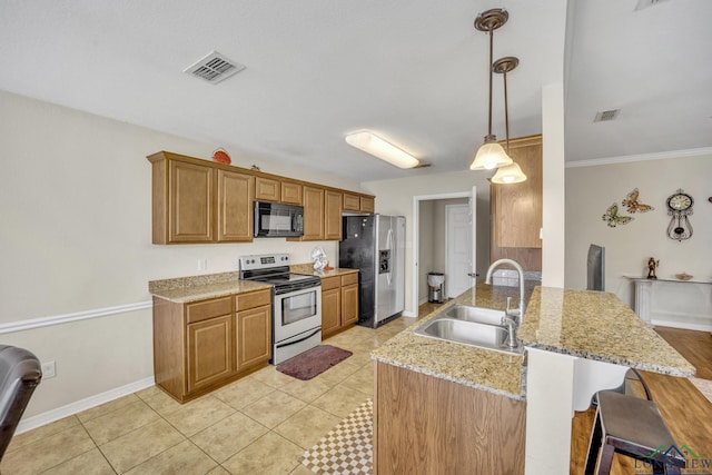 kitchen with stainless steel appliances, visible vents, a sink, and a breakfast bar area