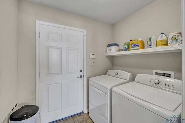 clothes washing area featuring laundry area, light tile patterned floors, and washer and clothes dryer