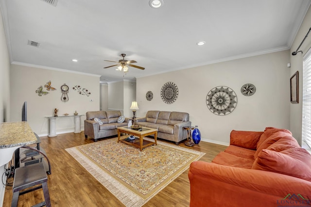 living area with crown molding, baseboards, and wood finished floors