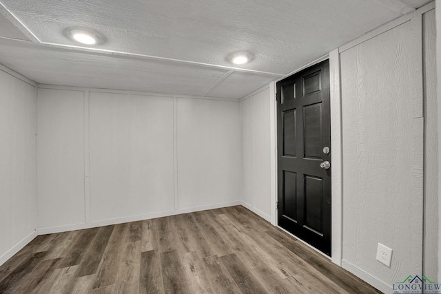 interior space with a textured ceiling and hardwood / wood-style flooring