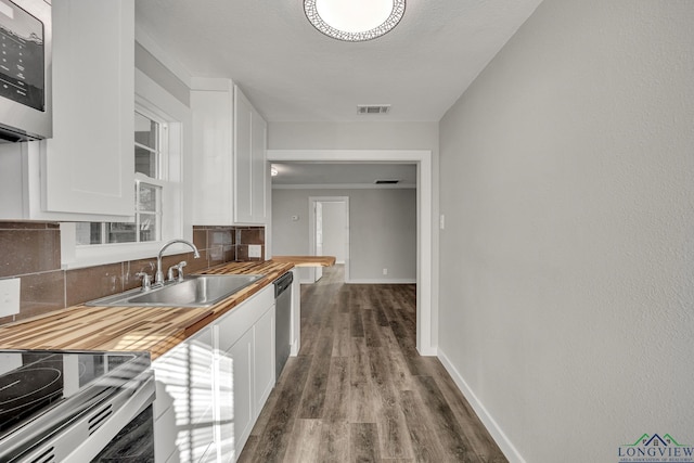 kitchen featuring wood counters, appliances with stainless steel finishes, white cabinetry, and sink