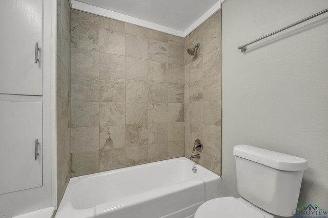 bathroom featuring toilet and tiled shower / bath