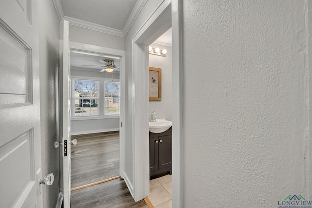 bathroom featuring vanity, tile patterned floors, ceiling fan, ornamental molding, and a textured ceiling