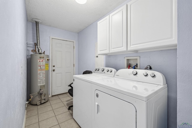 laundry room with washing machine and dryer, water heater, light tile patterned floors, cabinet space, and a textured ceiling