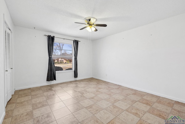 spare room featuring a textured ceiling, baseboards, and ceiling fan