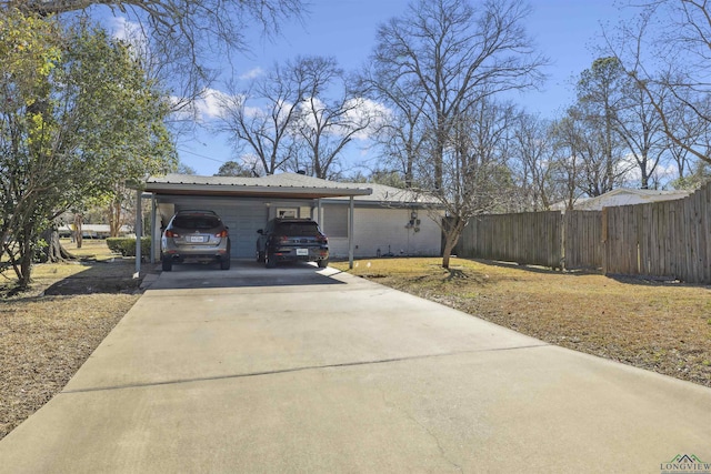 view of front of property with metal roof, a carport, driveway, and fence