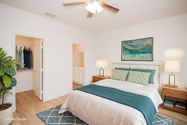 1146 Mission Creek Dr, Longview, TX 75601 - bedroom featuring light wood finished floors, a spacious closet, connected bathroom, a closet, and ceiling fan