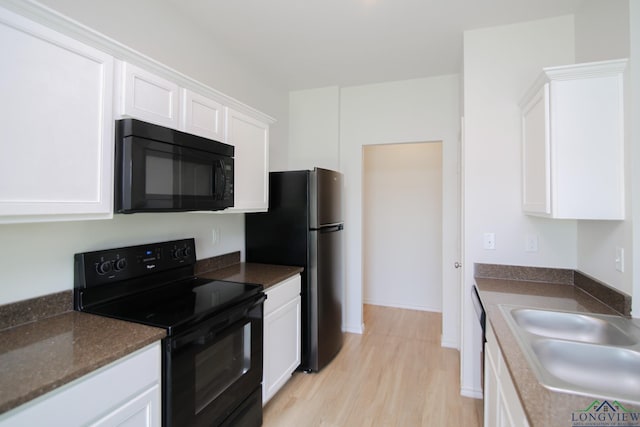 1146 Mission Creek Dr, Longview, TX 75601 - kitchen featuring black appliances, white cabinetry, and light wood-style flooring