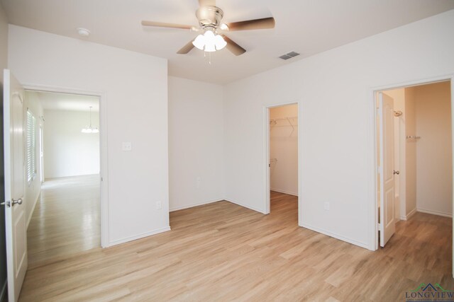 1146 Mission Creek Dr, Longview, TX 75601 - spare room with light wood finished floors, ceiling fan, and a chandelier