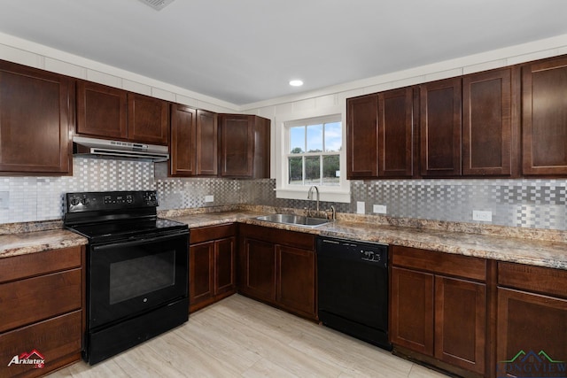 kitchen with light stone counters, dark brown cabinetry, sink, black appliances, and light hardwood / wood-style floors